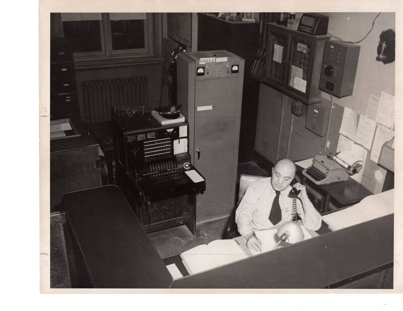 1 black and white photograph 8 x 10 Bergenfield Police officer inside station 1953.jpg