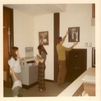1 colored photograph Gil Thomas hanging his donation of a photograph to the Bergenfield Library 1970.jpg
