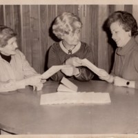 Mary Joyce Doyle and 2 other women sitting at a table together talking