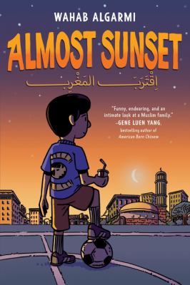 Cover for a Juvenile Graphic Novel. A young boy holding a soccer ball with his foot and a drink in his hand overlooks a sunset over a town. Text reads, "Almost Sunset." Written by Wahab Algarmi.
