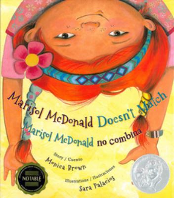 Cover for a Vox/Wonderbook. A redheaded girl hangs upside down. She has a pink flower in her hair. Text reads, "Marisol McDonald Doesn't Match. Marisol McDonald no combina." Written by Monica Brown. Illustrated by Sara Palacios.